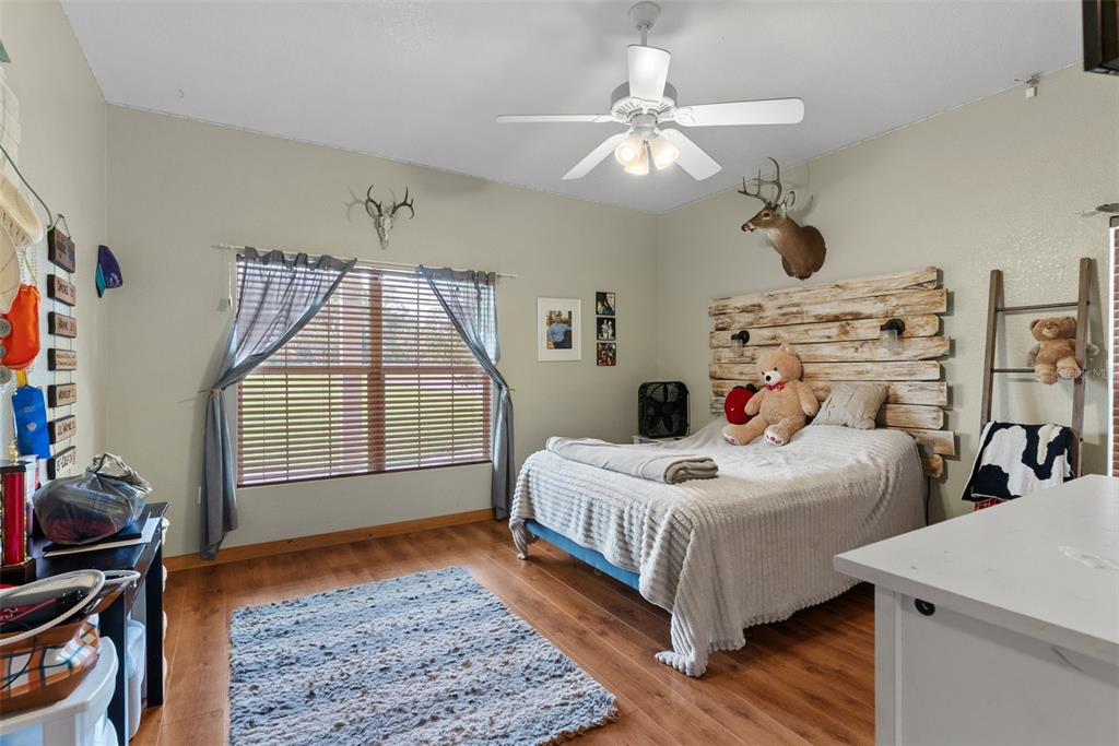 12136 McIntosh Road Thonotosassa, FL 33592 - Photo 20 of 44 a bedroom with bed and a chandelier