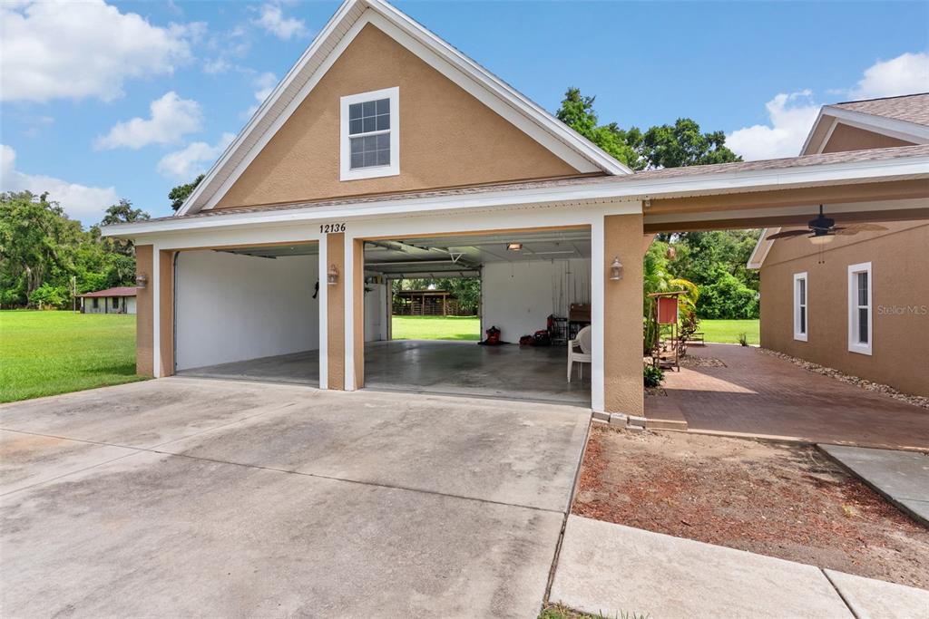 12136 McIntosh Road Thonotosassa, FL 33592 - Photo 29 of 44 a view of a house with backyard and a garage