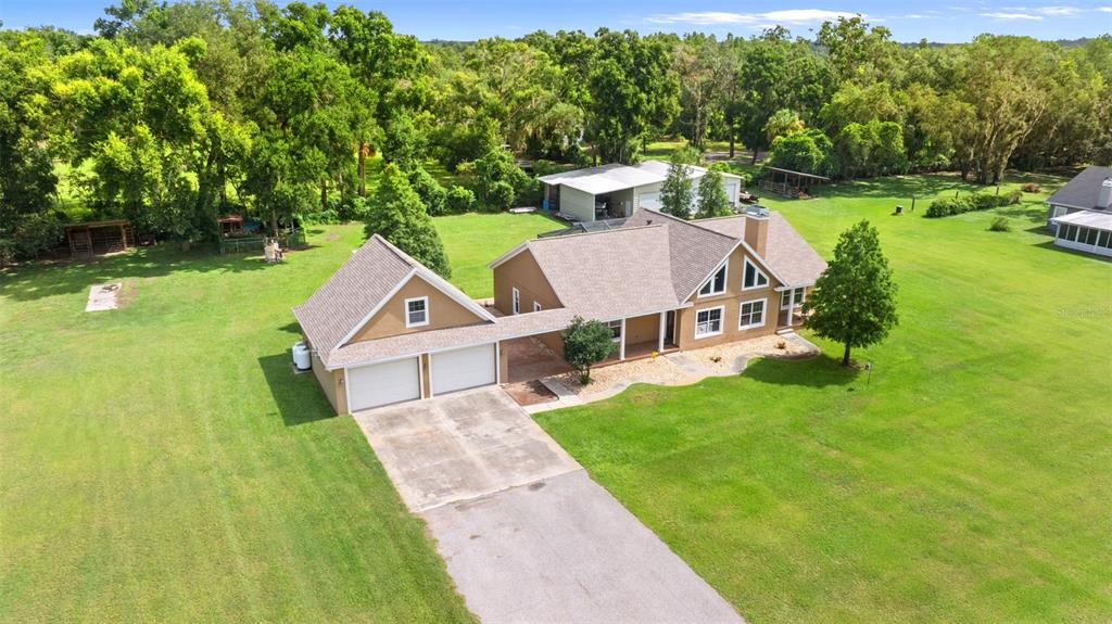 12136 McIntosh Road Thonotosassa, FL 33592 - Photo 34 of 44 a view of a house with a big yard potted plants and large tree