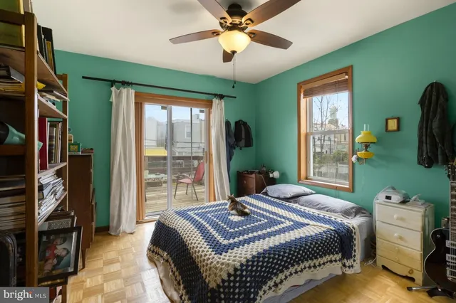 a bedroom with a bed a window and a flat screen television