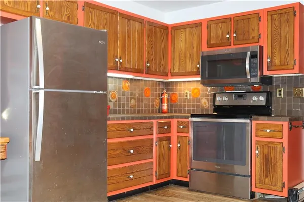 a kitchen with stainless steel appliances granite countertop a refrigerator and a stove