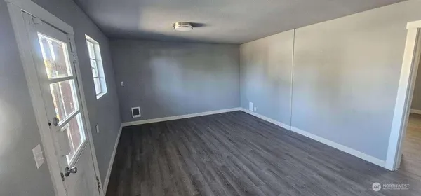 a view of a room with wooden floor and a window