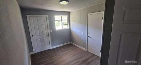 an empty room with wooden floor and closet