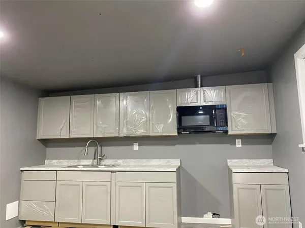 a kitchen with stainless steel appliances a sink a stove a microwave and cabinets