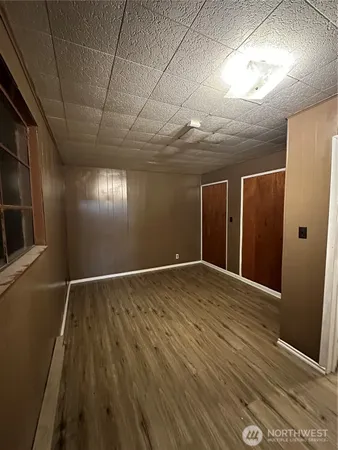 a view of an empty room with wooden floor