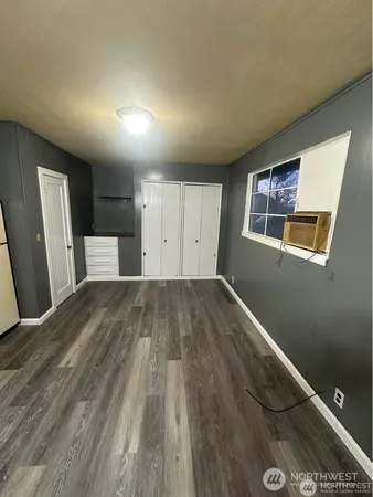 a view of empty room with wooden floor