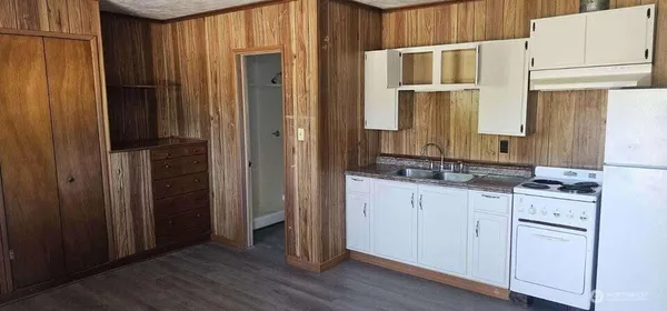 a view of a hallway with stainless steel appliances
