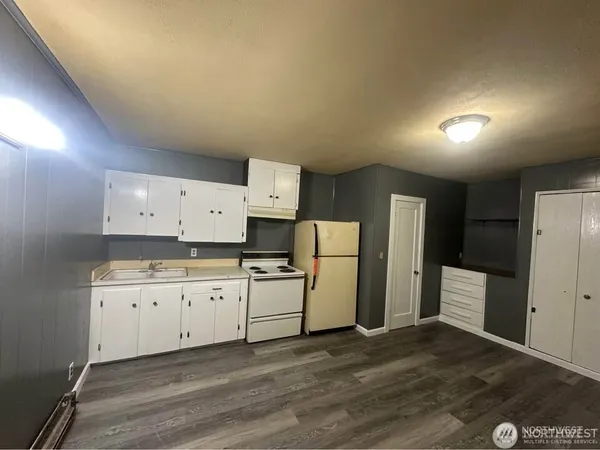 a kitchen with refrigerator and cabinets
