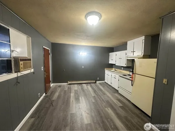 a kitchen with refrigerator and white cabinets