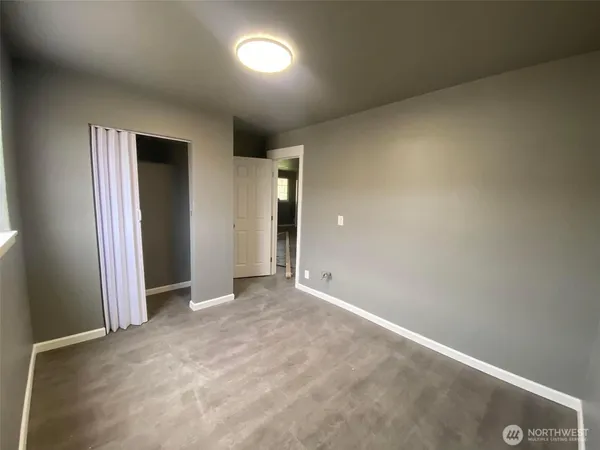 an empty room with closet and wooden floor