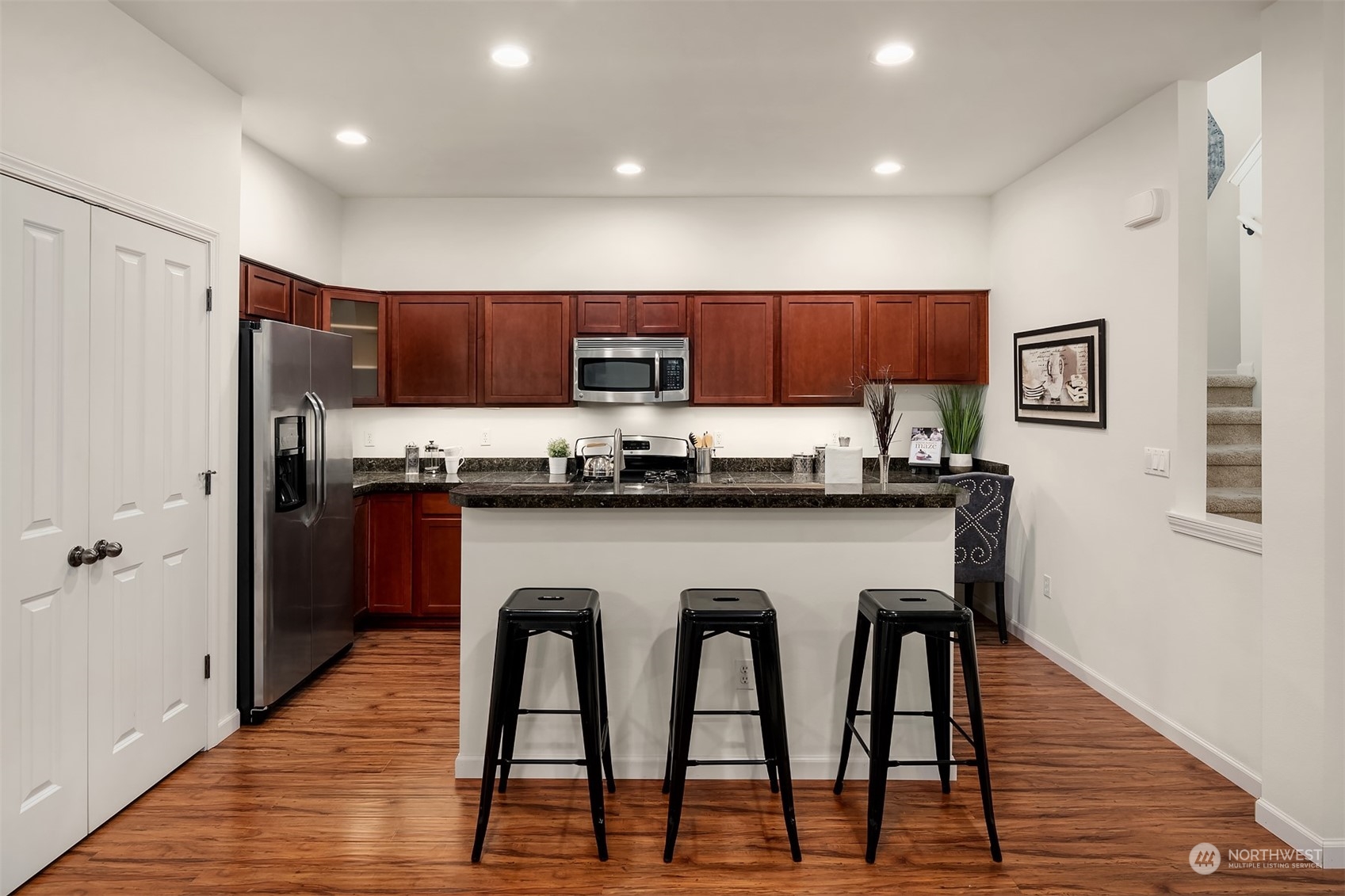 21621 11th Drive Southeast Bothell, WA 98021 - Photo 5 of 31 a kitchen with stainless steel appliances granite countertop a table chairs refrigerator and microwave