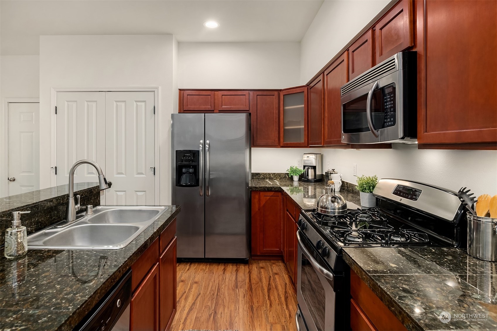 21621 11th Drive Southeast Bothell, WA 98021 - Photo 6 of 31 a kitchen with stainless steel appliances granite countertop a sink stove and refrigerator