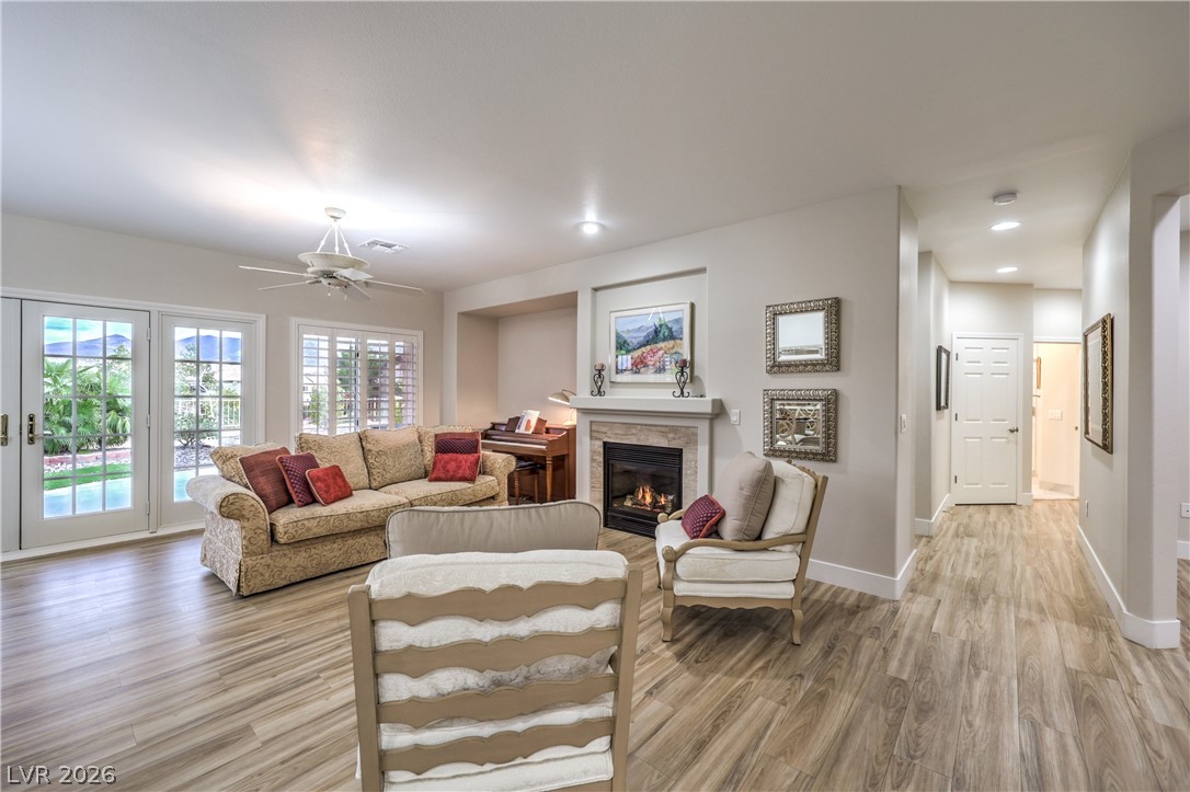 2072 Crown View Street Henderson, NV 89052 - Photo 4 of 53 Spacious Great Room with Ceiling Fan, Gas Fireplace, Laminate Wood Flooring, and French Doors leading to Backyard