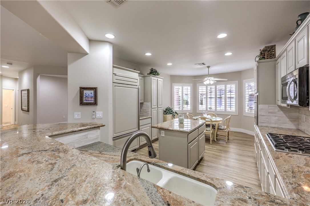 2072 Crown View Street Henderson, NV 89052 - Photo 10 of 53 Island Kitchen boasts Granite Countertops, Upgraded Cabinets w/ Pull-Out Shleves, Breakfast Bar, Nook w/ Bay Window & Ceiling Fan, Pantry, Recessed Lighting, R/O System, Sub Zero Refridgerator, B/I Wolf Oven, Wolf Gas Cooktop, Microwave, and Dishwasher