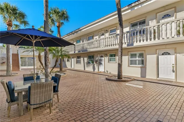 a roof deck with a table and chairs under an umbrella