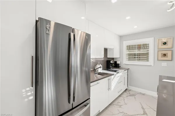 a kitchen with stainless steel appliances granite countertop a refrigerator stove and sink
