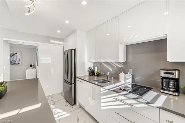 a kitchen with a refrigerator and a stove top oven