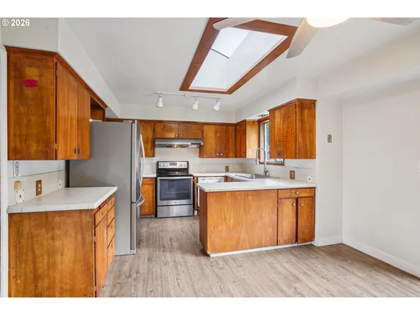 a kitchen with stainless steel appliances granite countertop a sink a stove and a refrigerator