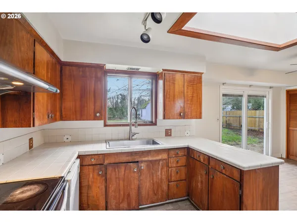 a kitchen with a sink a window and cabinets