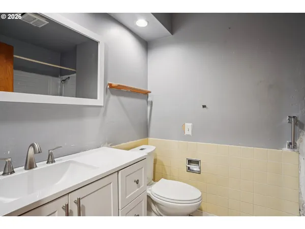 a bathroom with a sink a toilet and mirror