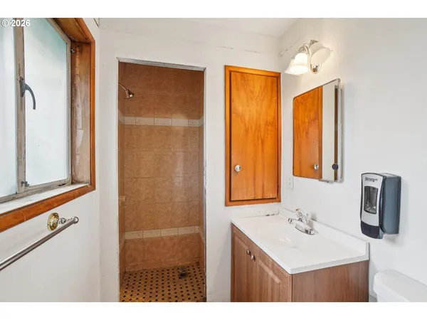 a bathroom with a sink a mirror and a shower