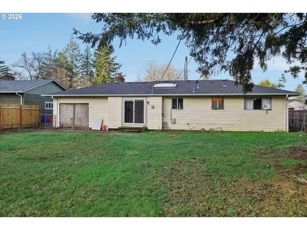 a view of a yard in front of a house with large tree