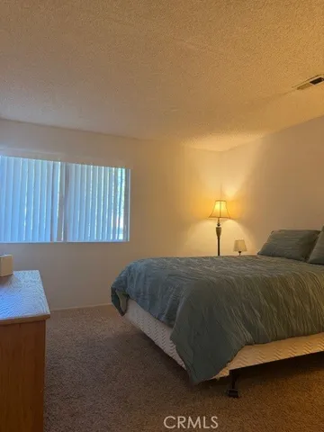 a living room with a bed furniture and a night stand