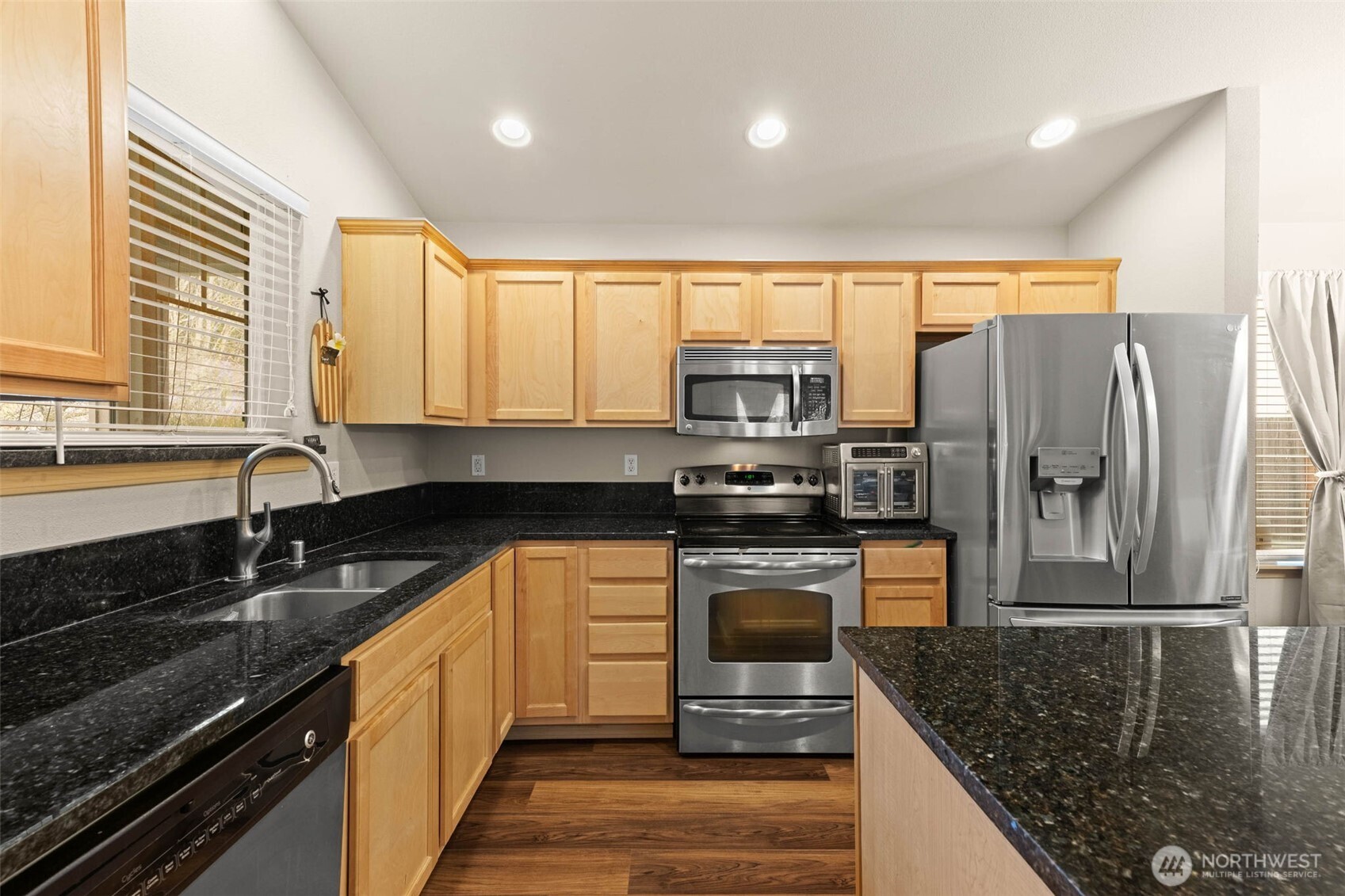20009 96th Avenue East Graham, WA 98338 - Photo 9 of 40 a kitchen with stainless steel appliances granite countertop a sink stove and refrigerator