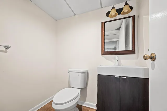a bathroom with a toilet a sink and mirror