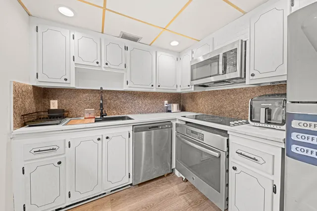 a kitchen with cabinets appliances and a sink