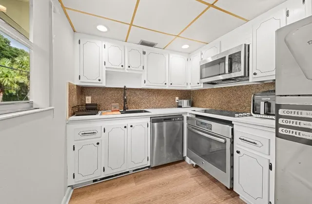 a kitchen with cabinets appliances and a window