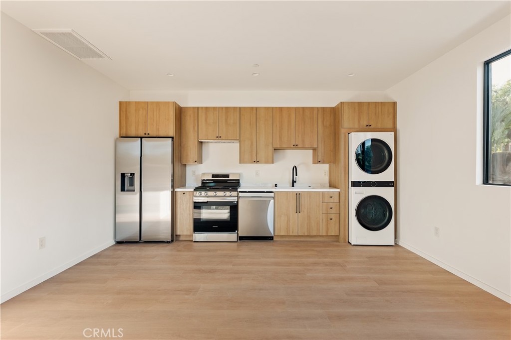 17852 Saticoy Street Reseda, CA 91335 - Photo 11 of 28 a kitchen with stainless steel appliances granite countertop a refrigerator a stove and a microwave oven with cabinets