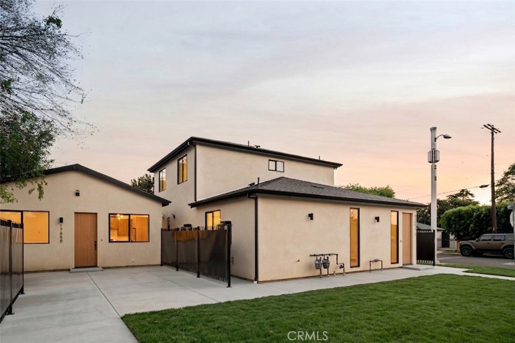 17852 Saticoy Street Reseda, CA 91335 - Photo 26 of 28 a view of a white house with a big yard and large trees