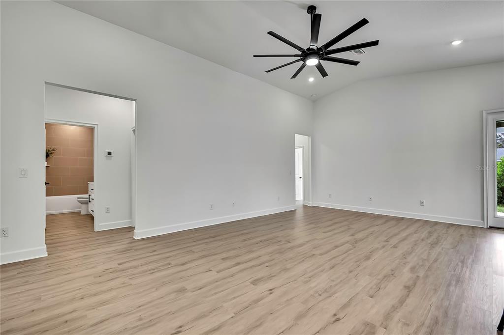6589 Freeport Drive Spring Hill, FL 34608 - Photo 13 of 57 a view of a livingroom with a hardwood floor and a ceiling fan