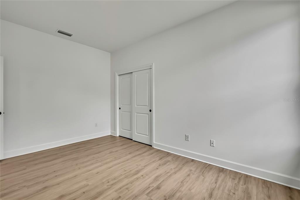 6589 Freeport Drive Spring Hill, FL 34608 - Photo 21 of 57 a view of an empty room with wooden floor