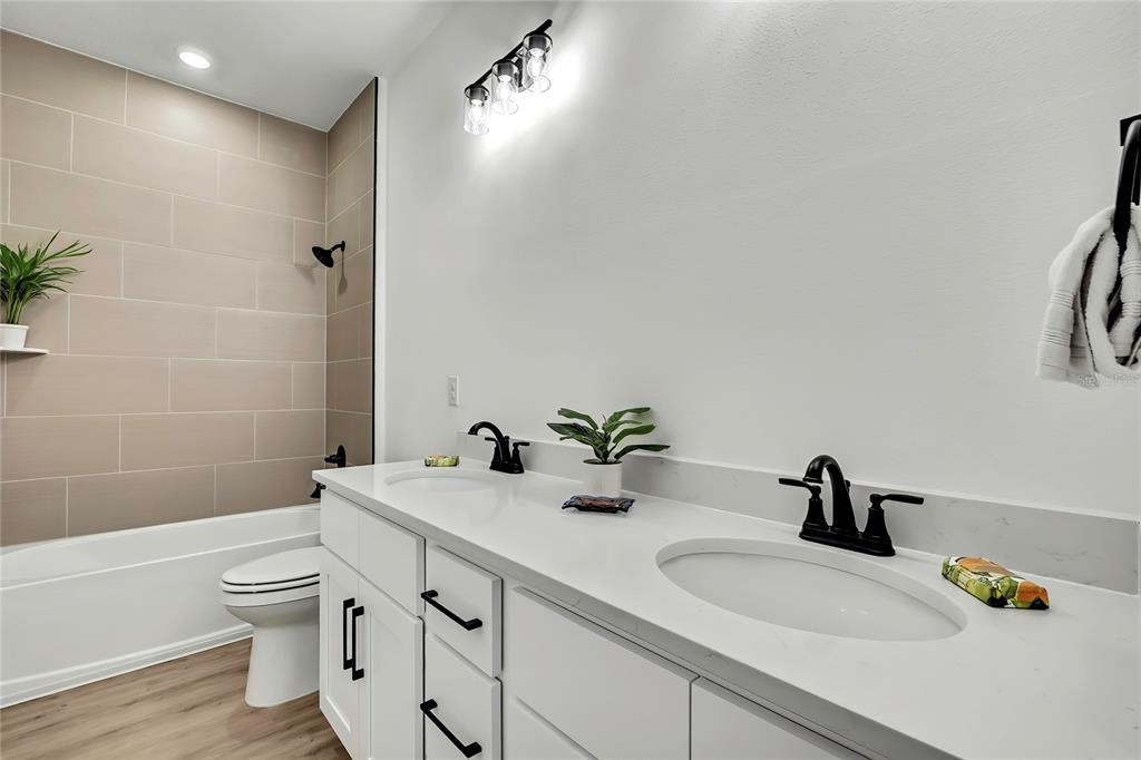 6589 Freeport Drive Spring Hill, FL 34608 - Photo 23 of 57 a bathroom with a double vanity sink toilet and a tub
