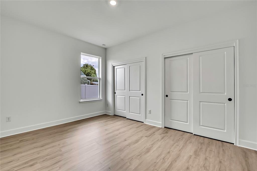 6589 Freeport Drive Spring Hill, FL 34608 - Photo 25 of 57 a view of an empty room with wooden floor and a window