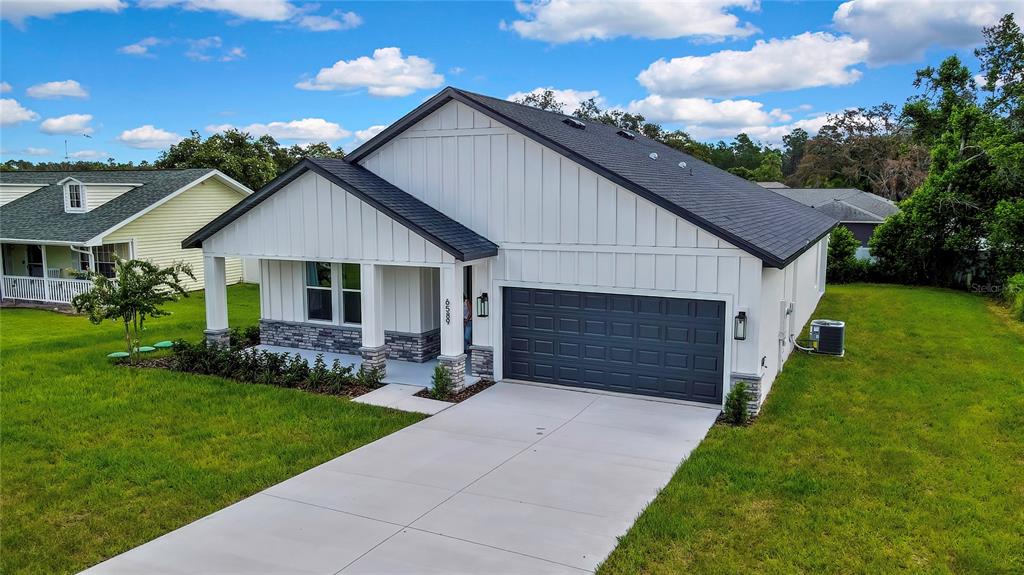 6589 Freeport Drive Spring Hill, FL 34608 - Photo 41 of 57 a front view of a house with a garden and yard