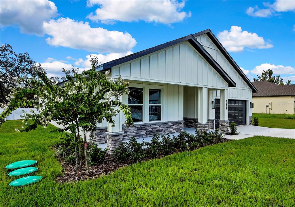 6589 Freeport Drive Spring Hill, FL 34608 - Photo 48 of 57 a front view of house with a garden and patio