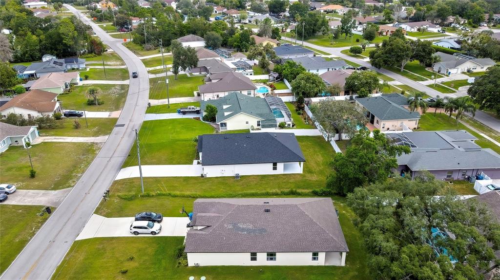 6589 Freeport Drive Spring Hill, FL 34608 - Photo 51 of 57 an aerial view of a house with a garden and lake view