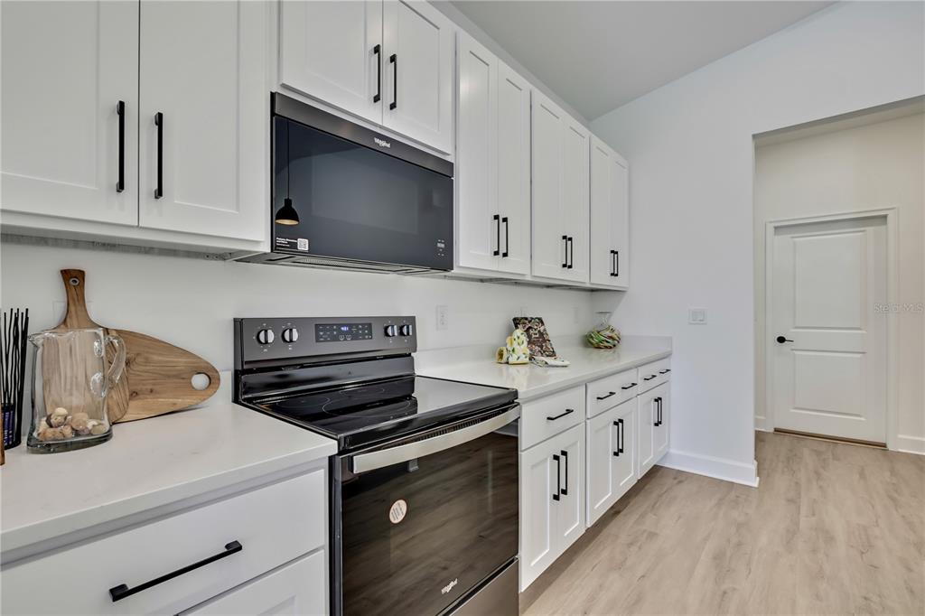 6589 Freeport Drive Spring Hill, FL 34608 - Photo 10 of 57 a kitchen with stainless steel appliances granite countertop a stove a sink and white cabinets