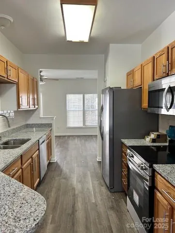 a kitchen with stainless steel appliances granite countertop a sink stove and refrigerator