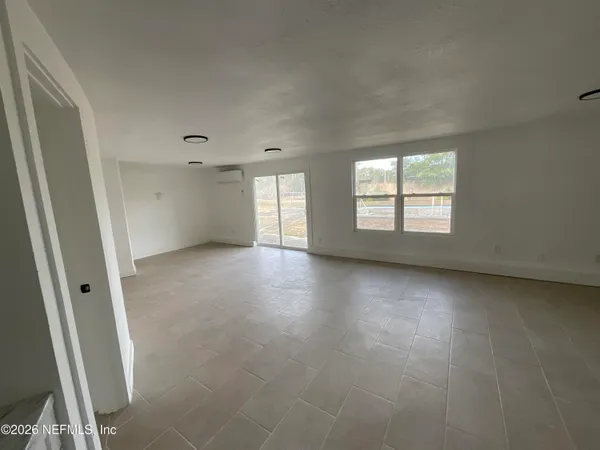 a view of a big room with windows and chandelier