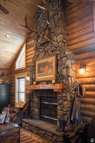18906 North Canyon Road Whiterocks, UT 84085 - Photo 8 of 65 Living room featuring a stone fireplace, log walls, high vaulted ceiling, and wooden ceiling