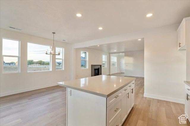 2033 Fortune Lane, Unit 462 Mapleton, UT 84664 - Photo 11 of 27 Kitchen featuring white cabinetry, decorative light fixtures, a center island, and a healthy amount of sunlight