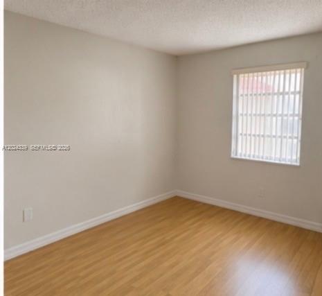 5401 Southwest 77th Court, Unit 202E Miami, FL 33155 - Photo 5 of 6 wooden floor in an empty room with a window