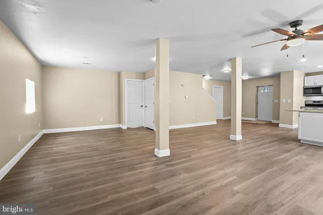 a view of a big room with wooden floor and a kitchen