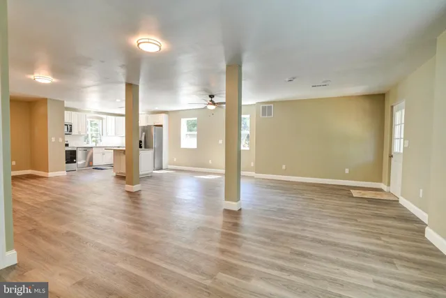 a view of a livingroom with wooden floor and a ceiling fan