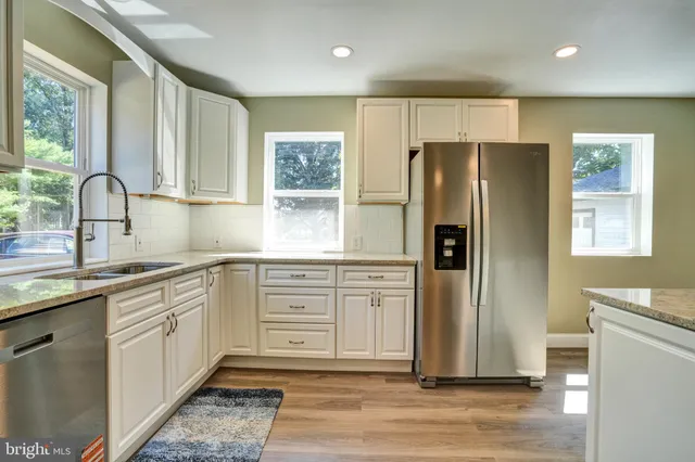 a kitchen with stainless steel appliances granite countertop a refrigerator sink and cabinets