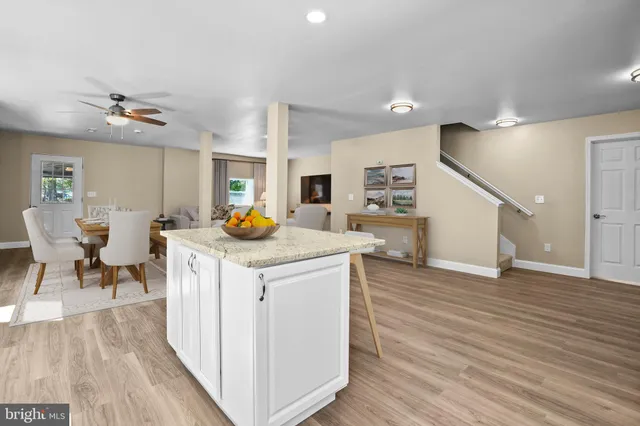 a kitchen with stainless steel appliances granite countertop a table chairs and a refrigerator
